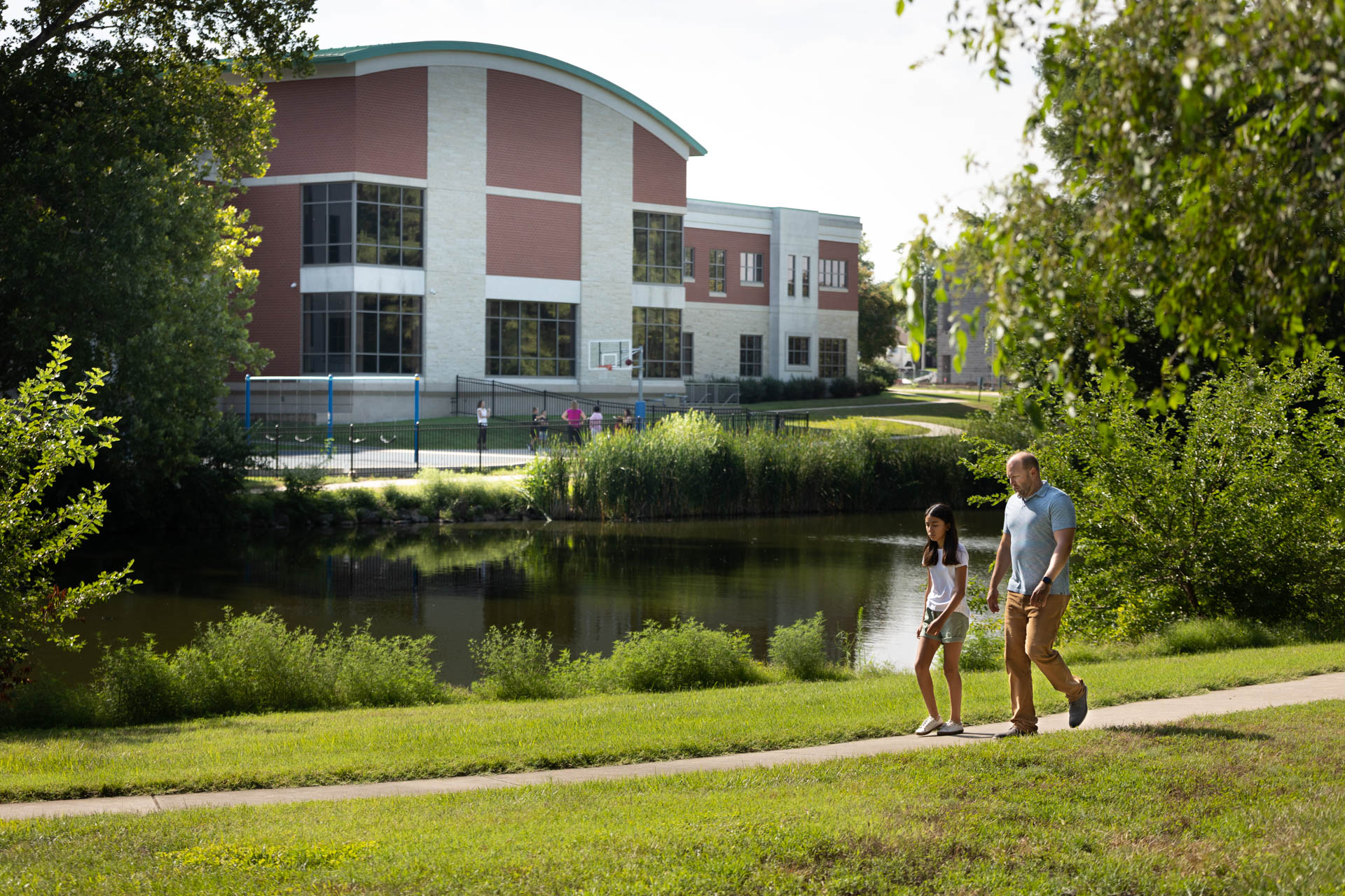 man walking with young girl along the lake outside of Family Service and Guidance Center.